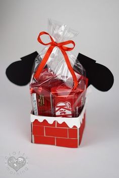 a red box filled with chocolates in front of a black mouse ears shaped paper