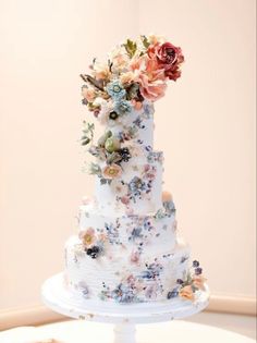 a white wedding cake with flowers on the top and bottom tier is displayed in an instagram