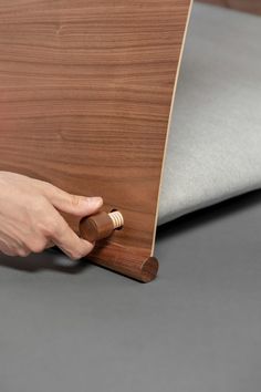 a person is opening the door to a bed with a wooden headboard and foot board