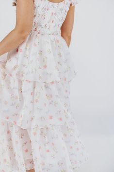 Meet the "It" dress of the season: this midi is our new favorite, forever and always! Crafted from a premium fabric in the most exquisite floral pattern, it features a feminine, flouncy silhouette and ruffle details that will capture your heart - and the spotlight. Whatever special event is next on your calendar - spring weddings, maternity photos, christenings or baby showers - the Forever & Always will set you apart from the crowd in the most elegant of ways. FIT: Runs true to size. Dress will accommodate most baby bumps; note that the bodice is smocked, which could prove restrictive if you are in advanced maternity and carrying high. MATERIAL: Self: 100% Polyester; Lining: 100% Cotton. Hand wash cold; do not bleach, do not tumble dry. Line dry, low iron if needed. GARMENT DETAILS: Light Feminine Tiered Midi Dress For Summer, Spring Feminine Tea Length Dress, Feminine Spring Tea Length Dress, Feminine Tea Length Spring Dress, Feminine Fitted Maxi Dress With Tiered Skirt, Feminine Fitted Tiered Maxi Dress, Tiered Midi Dress For Wedding, Feminine Flowy Maxi Dress For Garden Party, Feminine Summer Tiered Skirt Dress