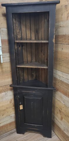 an old black bookcase with wooden shelves