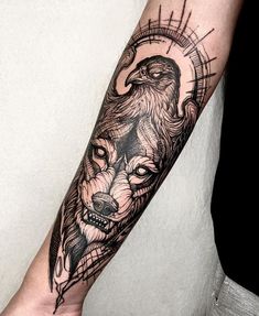 a man's arm with an eagle and wolf tattoo on it