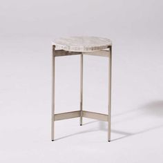 a small table with a marble top and metal legs, against a white background that appears to be empty