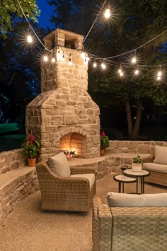 an outdoor fireplace with patio furniture and string lights strung around it, on instagram