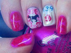 a person holding a pink and white manicure with horse designs on the nail polish