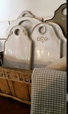 a wooden crate filled with white dishes and utensils on top of a table