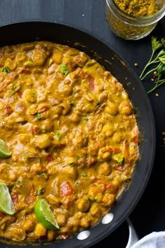 a skillet filled with food and garnished with limes on the side