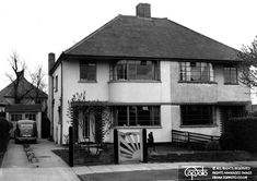 an old black and white photo of a house with a car parked in the driveway