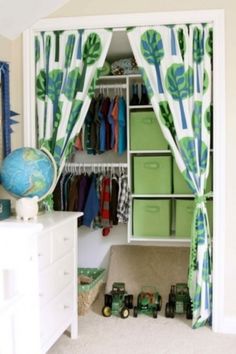 a closet with green and white curtains, drawers, and toys