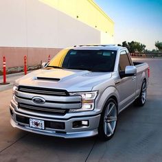 a silver truck parked in front of a building