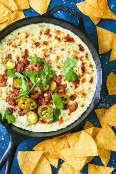 a skillet filled with tortilla dip surrounded by tortilla chips