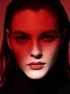 a woman's face is shown with red light coming from her eyes and nose