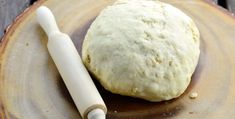 a piece of bread sitting on top of a plate next to a rolling pin