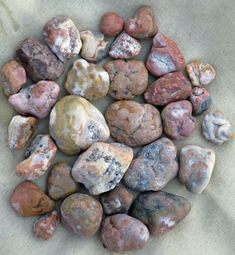 several rocks are arranged in a circle on a piece of paper with a cloth underneath them