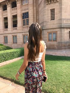 a woman standing in front of a large building