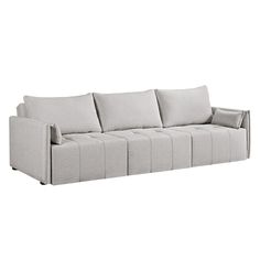 a white couch with four pillows on it's back and one arm facing the camera