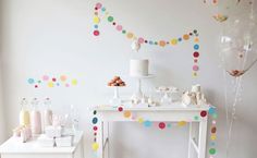 a party table with confetti and balloons