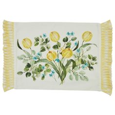 a white pillow with yellow flowers and green leaves on the front, fringe trim around the edges