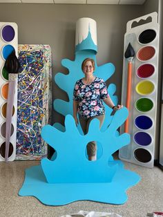 a woman is standing in front of some art supplies