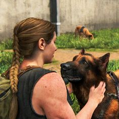 a woman is petting a dog in the grass