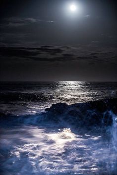 the moon is shining over the ocean waves