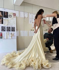 a woman in a wedding dress getting ready to go into the bridal gown she is wearing