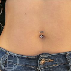 a woman's stomach with a diamond ring on the end of her tummy