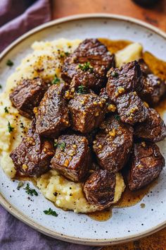 a white plate topped with meat and mashed potatoes