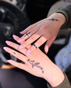 two women with matching tattoos on their hands are holding each other's hand together