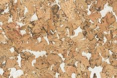 a close up view of the surface of a cork board with white and brown paint on it