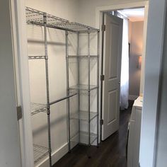 an empty closet with shelves in it and a door leading to another room behind the closet