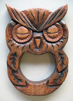 an owl shaped wooden wall hanging on the wall