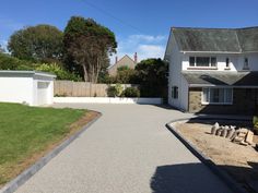 an empty driveway in front of a white house