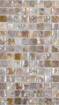 a close up view of a mosaic tile wall with white and brown tiles on it