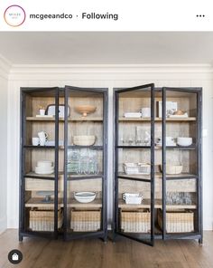 an open bookcase with baskets and dishes in it on top of a hard wood floor