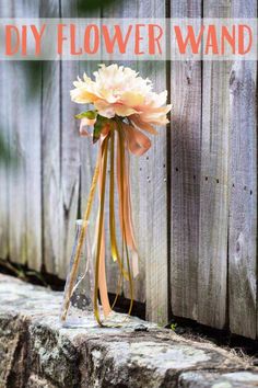 a vase filled with flowers sitting on top of a wooden fence