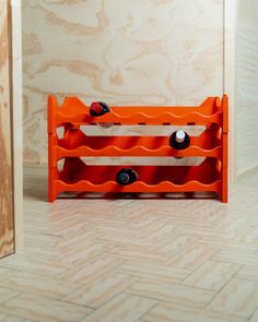 an orange wine rack sitting in the corner of a room