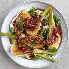 a white plate topped with artichokes covered in sauce and garnish