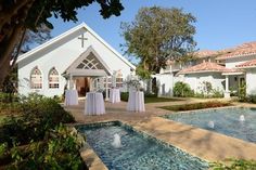 an outdoor wedding setup in front of a church with white linen draped tables and chairs