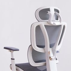 an office chair with wheels on the back and armrests, sitting in front of a white wall