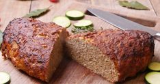 a sliced loaf of bread on a cutting board with cucumbers