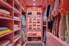 an organized closet with pink walls and shelving