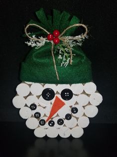 a green hat with buttons on it sitting next to a pile of white buttons and a bag