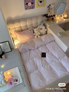 a bed with two teddy bears sitting on it's headboard in a bedroom