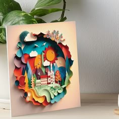 a card with an image of a castle in the middle and clouds above it on top of a table next to a potted plant