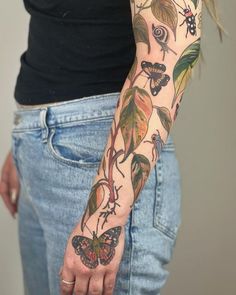 a woman's arm with tattoos on it and butterflies in the air above her