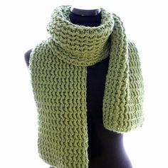 a green knitted scarf sitting on top of a mannequin