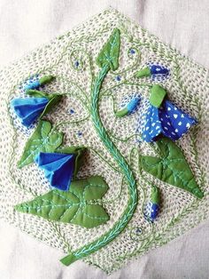 some blue flowers and green leaves on a white doily