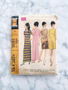 an old sewing book with three women's dresses on it