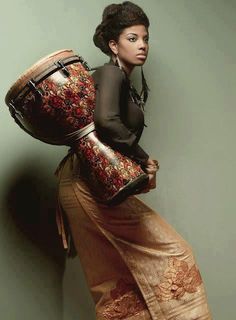 a woman holding a large drum in her hands